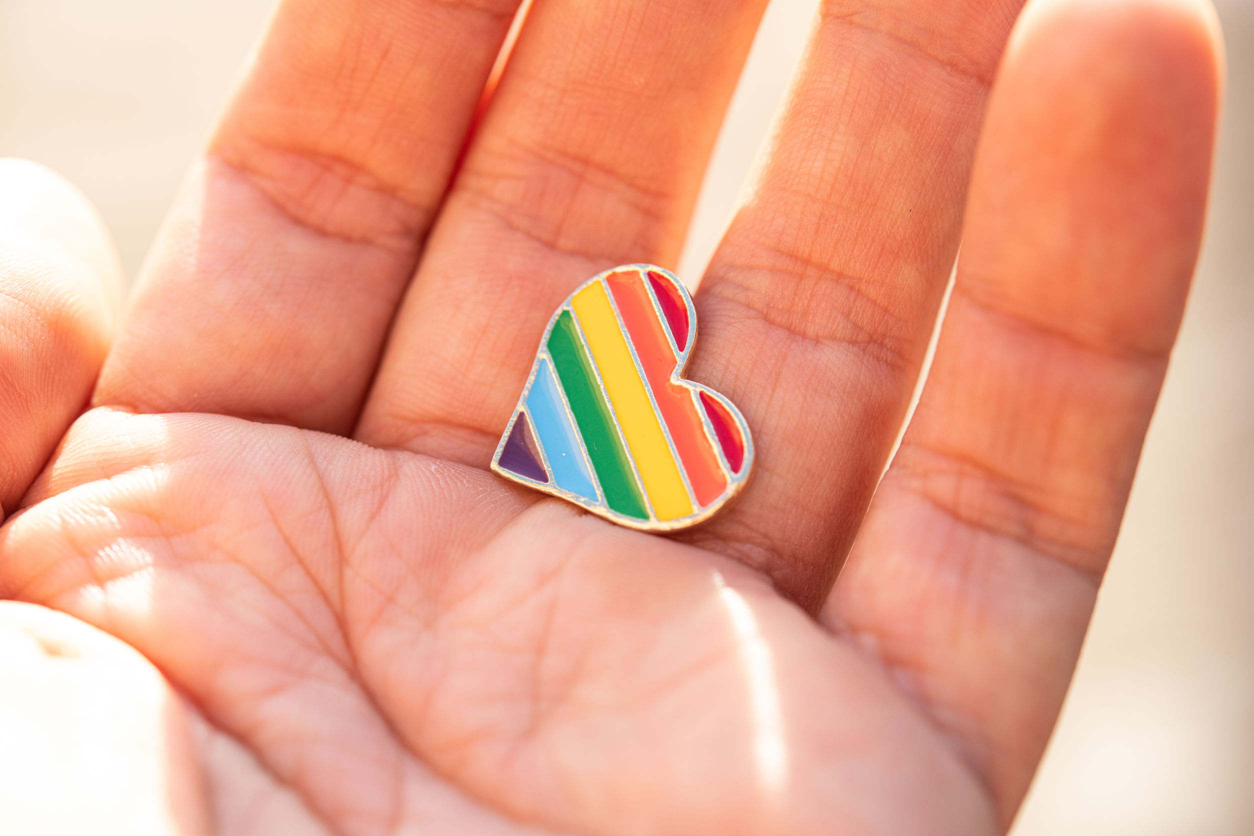 Photo: Hand holding a rainbow-coloured heart shape